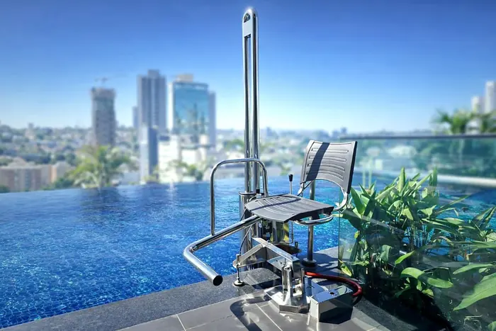 AccessPool, elevador hidráulico para piscina, instalado na borda de uma piscina de cobertura