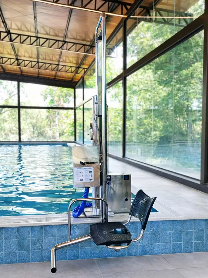 Elevador para piscina em piscina coberta com parede de vidro