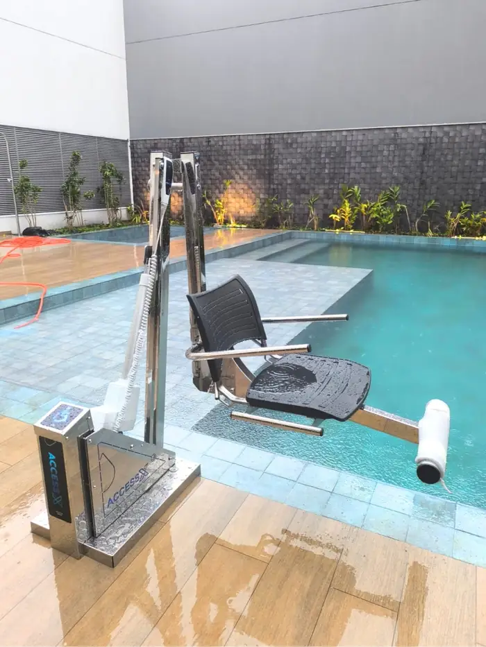 Cadeira de transferência para piscina ao lado de deck de madeira